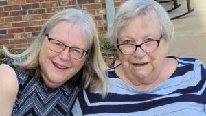 Two women with gray hair wearing glasses. 